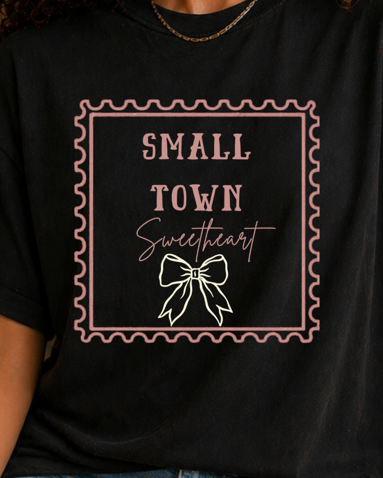 Woman wearing black Small Town Sweetheart western graphic t-shirt with denim shorts and cowboy hat