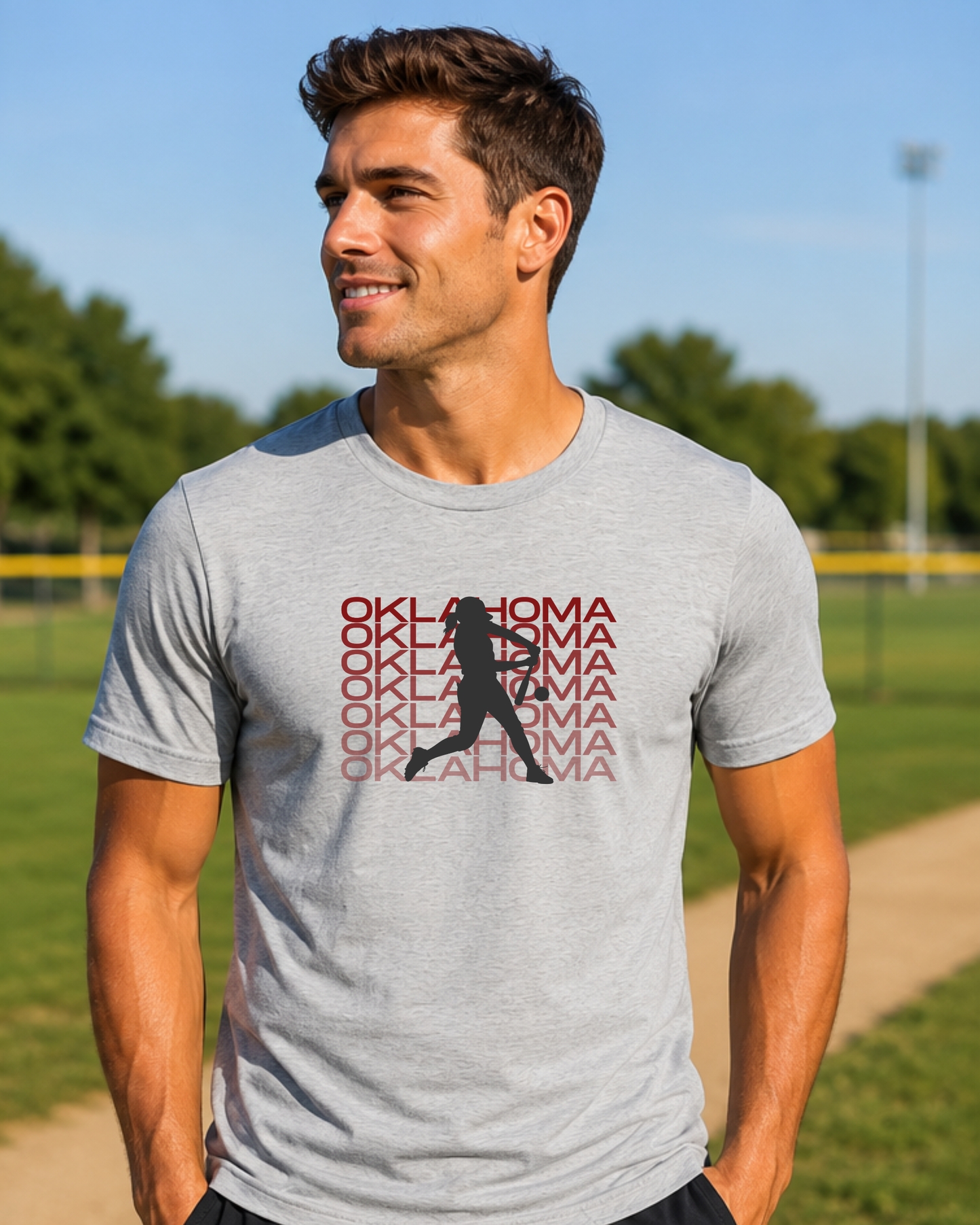 Man wearing an athletic heather Oklahoma softball game day graphic tee outdoors