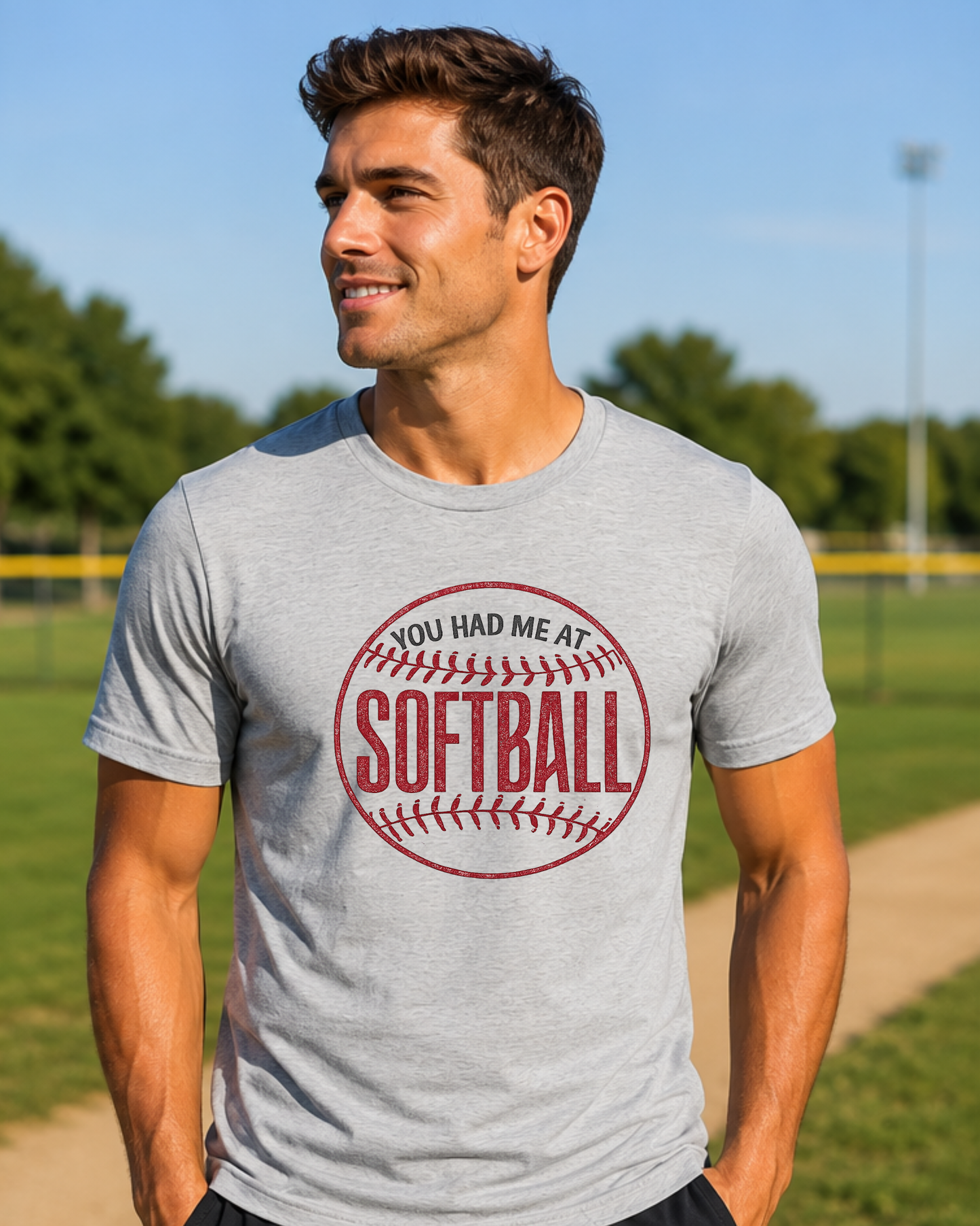 Man wearing a vintage you had me at softball softball shirt outdoors at a softball field