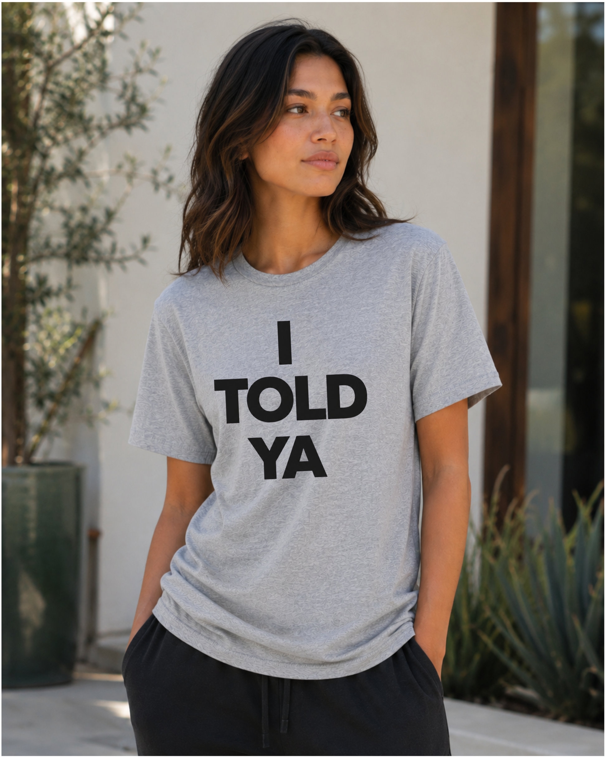 Woman wearing an Athletic Heather Bella+Canvas 3001 featuring a bold I Told Ya minimalist typography design by Wild Reed Apparel.