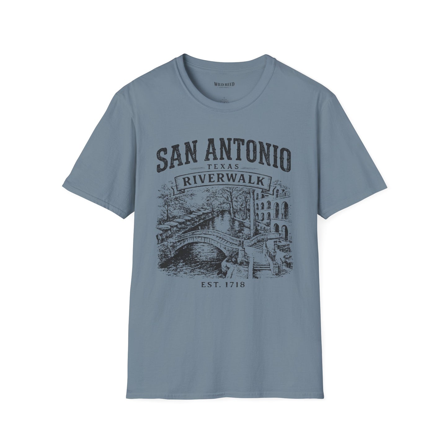 A stone blue crewneck t-shirt featuring a dark gray graphic print of the San Antonio Riverwalk with a bridge and buildings, displayed on a clean white background.
