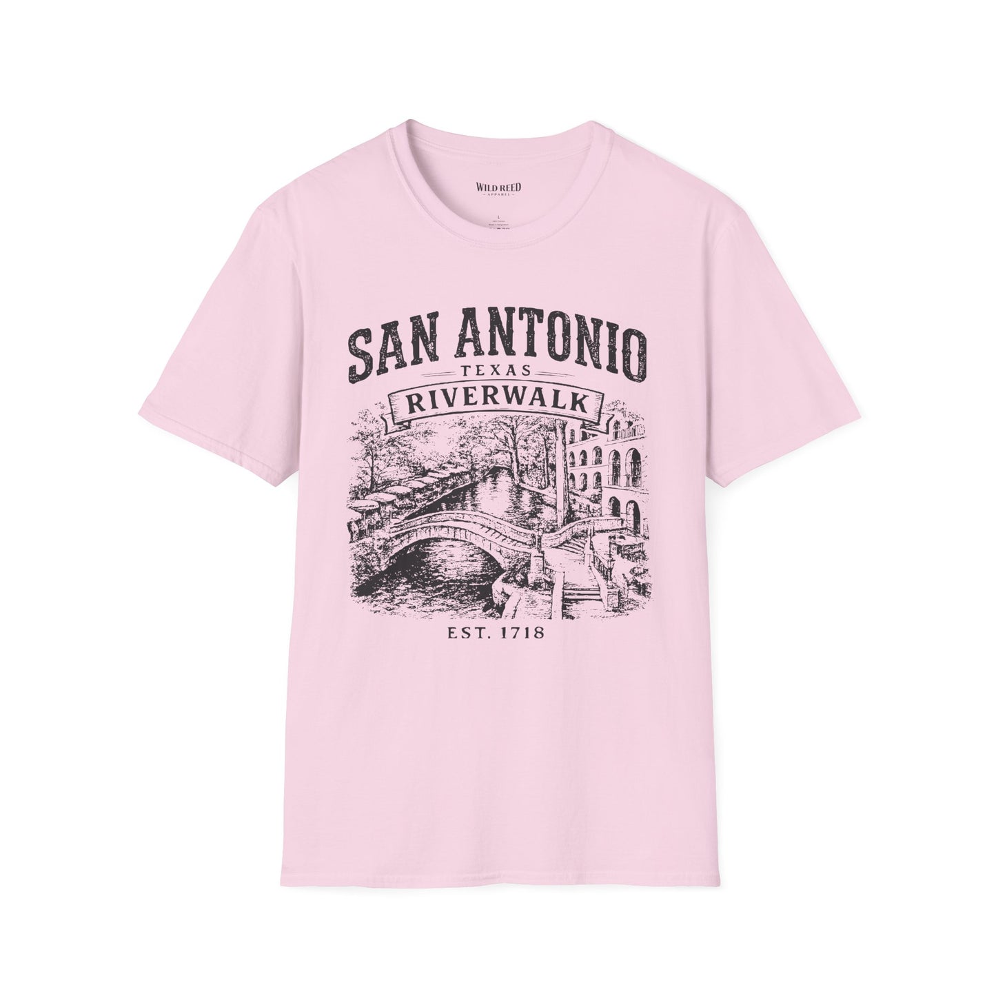 A light pink short-sleeve crewneck t-shirt with a black graphic print of San Antonio Riverwalk featuring a bridge and canal scene, displayed on a clean white background.