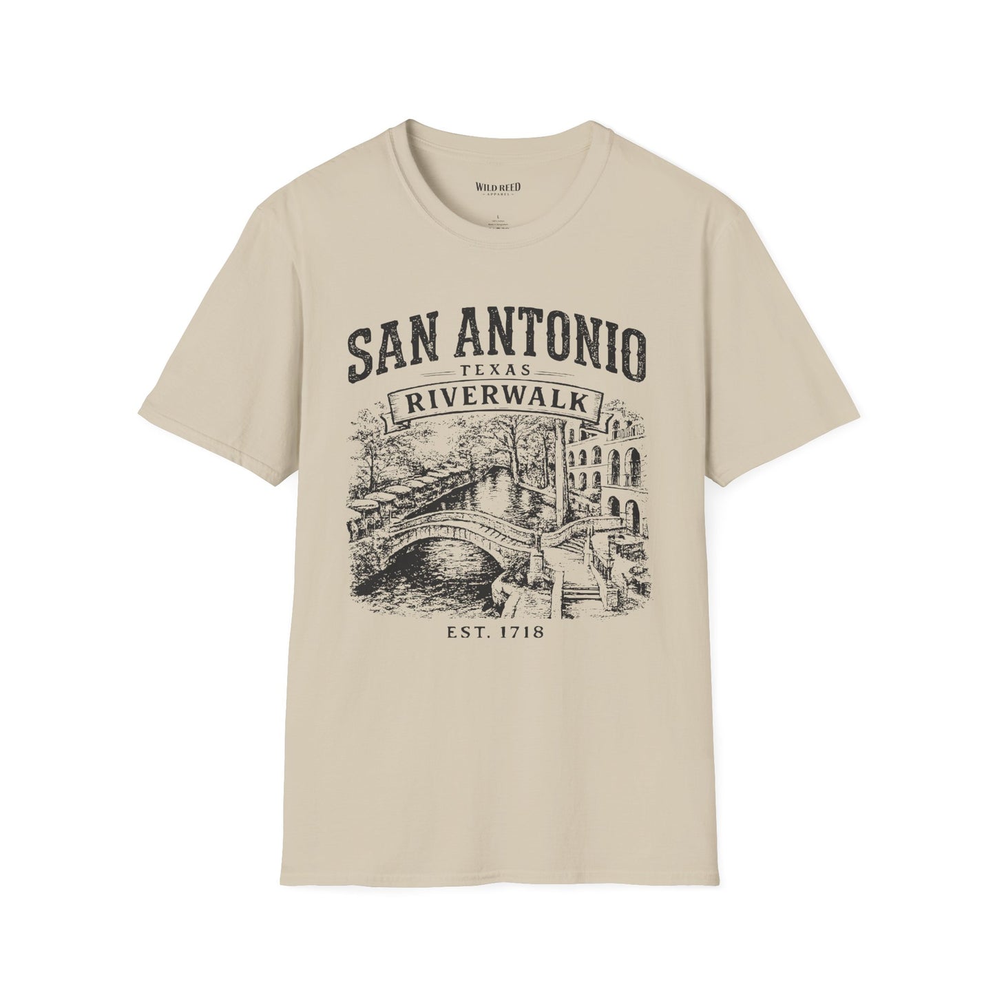 A beige short-sleeve crewneck t-shirt with a vintage-style black graphic print of San Antonio's Riverwalk featuring a bridge and canal scene.