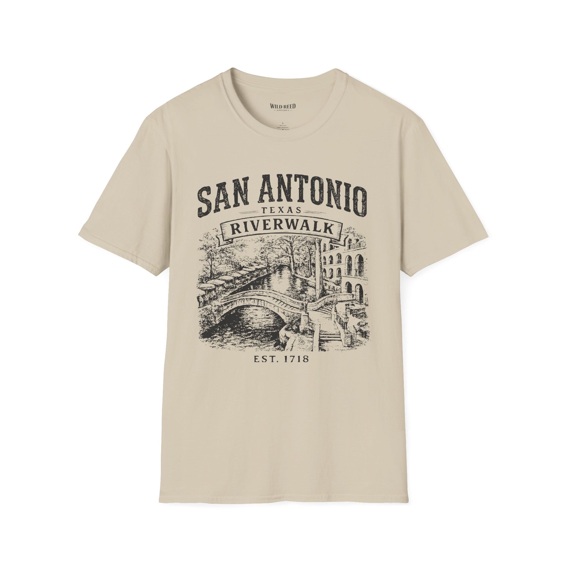 A beige short-sleeve crewneck t-shirt with a vintage-style black graphic print of San Antonio's Riverwalk featuring a bridge and canal scene.